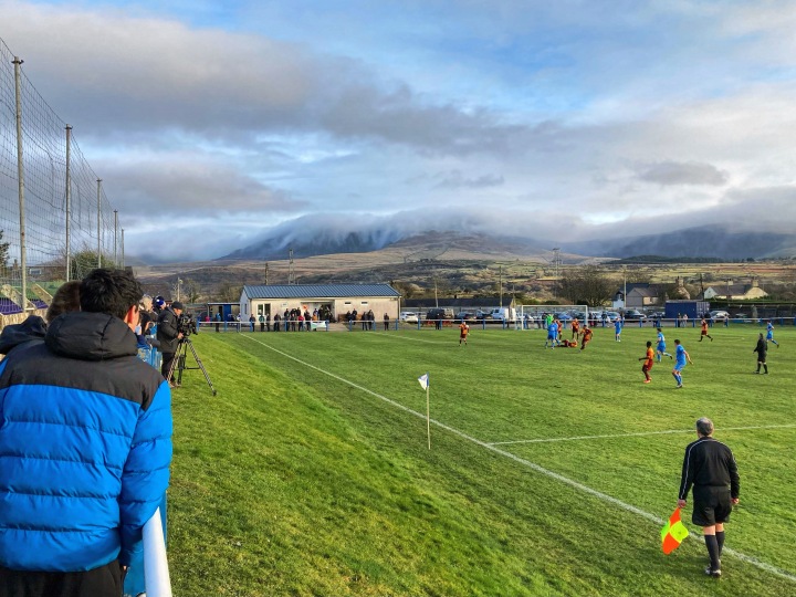 Cloud covers the mountain tops behind Nantlle Vale's ground as they play against Cardiff Corinthians