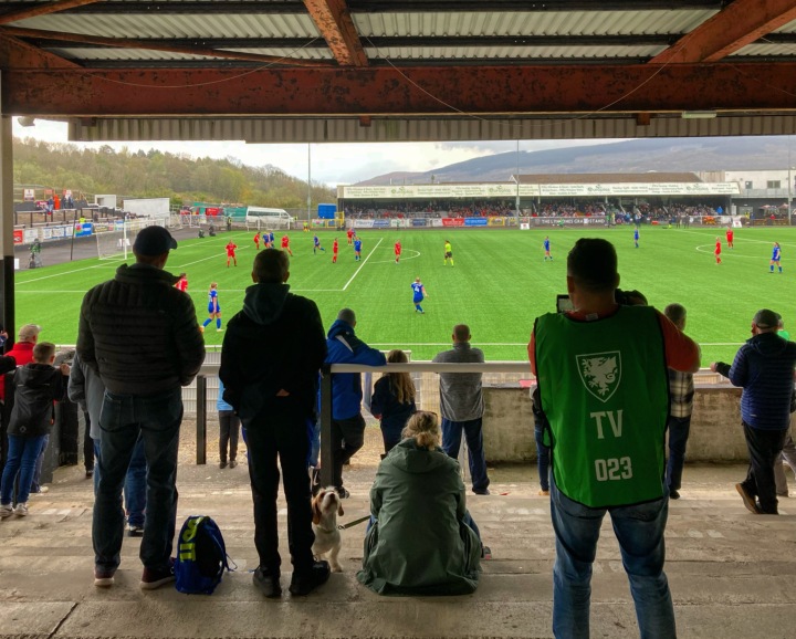 Supporters, a videographer and a dog watch on from the terrace at Penydarren Park as Cardiff City Women play Briton Ferry Llansawel