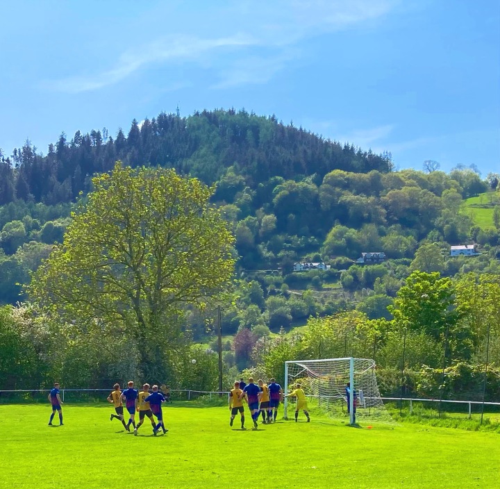 Llangollen Town defend a Builth Wells corner in front of a backdrop of tree-lined hills