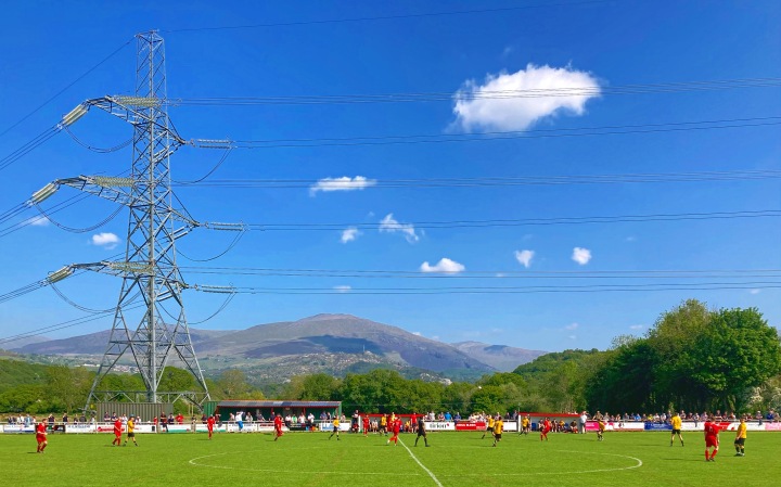 A huge pylon dominates the backdrop as Llanrug United play Llanberis